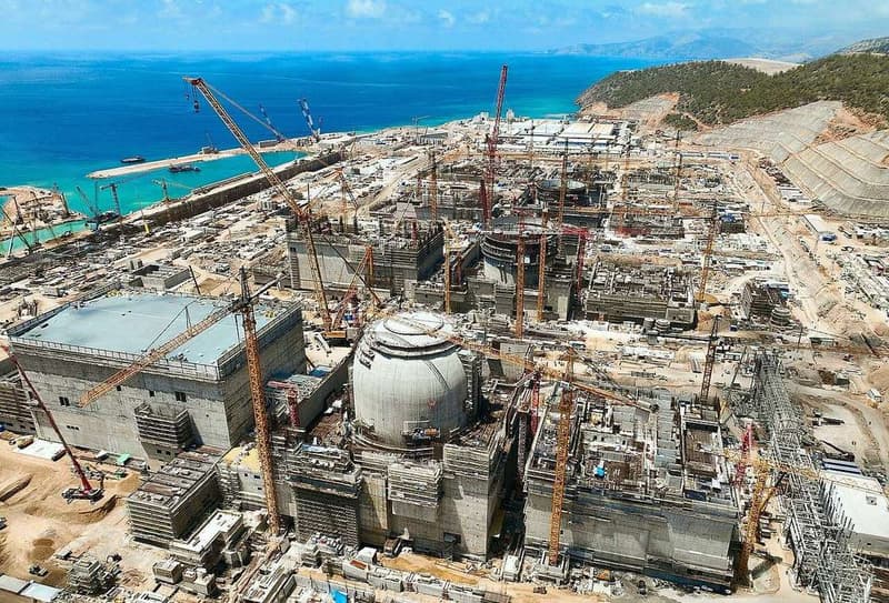Nuclear power plant under construction with cranes and reactor buildings