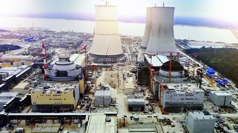 Cooling towers and reactor buildings rising at a nuclear power plant construction site