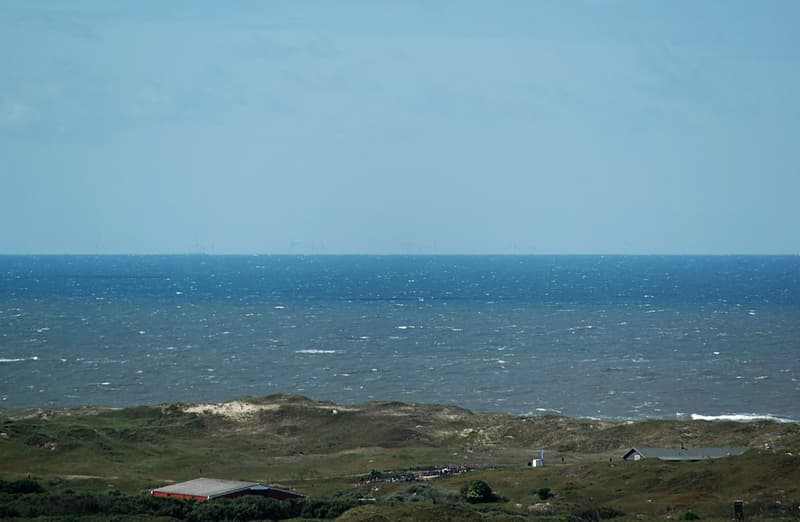 The alpha ventus offshore wind farm on the horizon off Lower Saxony, seen from the Norderney lighthouse