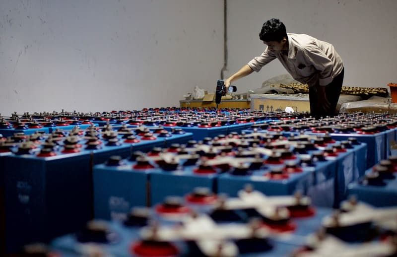 Worker assembling industrial battery cells in a factory