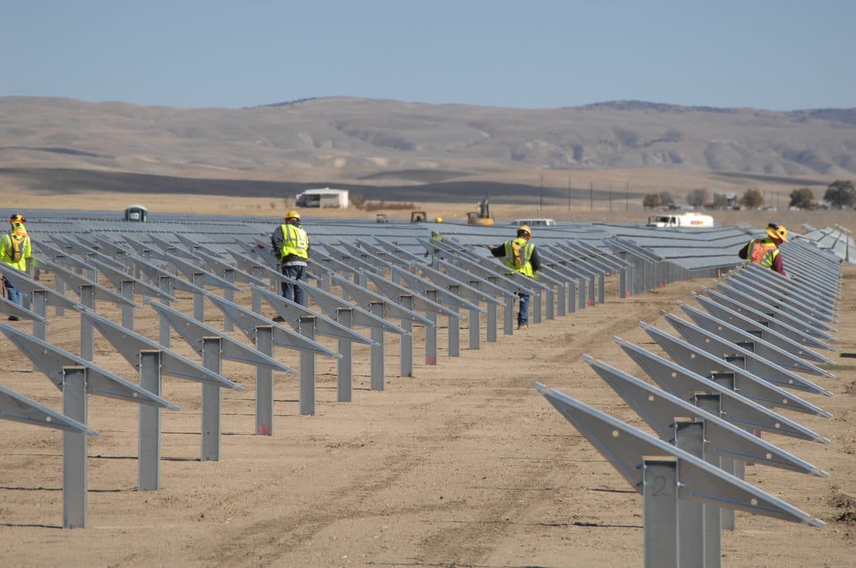 Aerial view of a utility-scale solar farm with rows of photovoltaic panels
